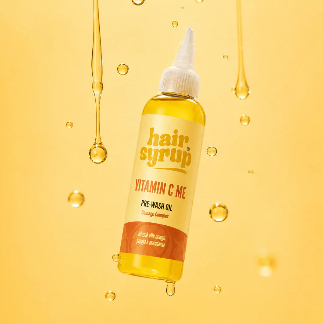 Hair syrup bottle with droplets on a yellow background