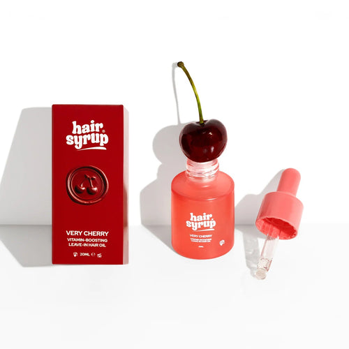 Hair Syrup Very Cherry hair growth promoting hair moisturizing treatment shown with its red packaging box, a clear bottle topped with a cherry, and an open dropper on a white background.