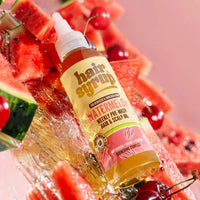 Hair syrup bottle on a bed of watermelon and cherries with a pink background